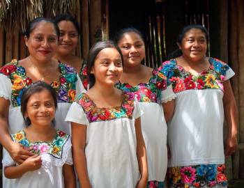 group of young girls with white shirts and floral collars on in mexico