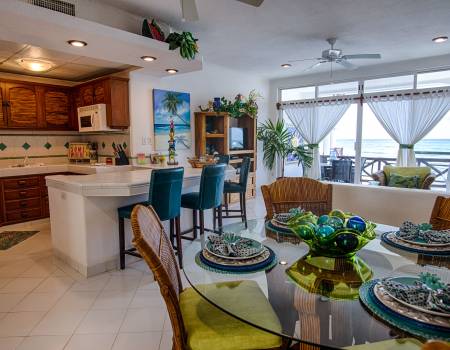 kitchen and dining room at playa caribe rental condo with bright decor and white flooring, walls, and tiling
